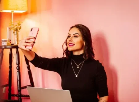 Influencer taking a selfie with a laptop, symbolizing Pakistan’s new 5% tax on digital content creators.