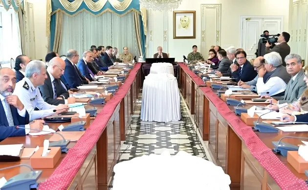 Government officials and ministers seated around a long conference table in Islamabad, discussing the extension of austerity measures and revised business hours until June 30, 2026.