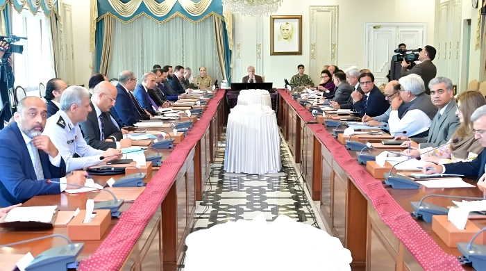 Government officials and ministers seated around a long conference table in Islamabad, discussing the extension of austerity measures and revised business hours until June 30, 2026.