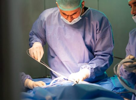 Bariatric surgeon performing a procedure in an operating room, representing medical and surgical treatment options for obesity.