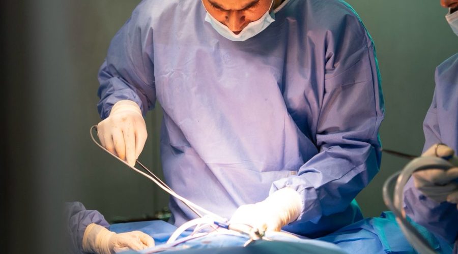 Bariatric surgeon performing a procedure in an operating room, representing medical and surgical treatment options for obesity.